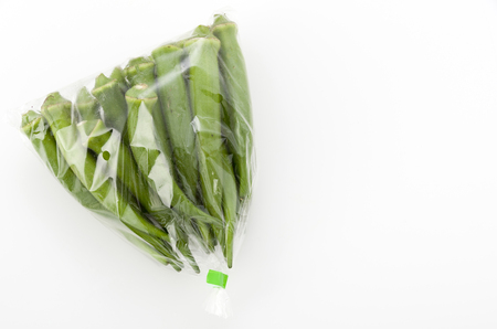 fresh okra in plastic bag isolated white backgroundの写真素材