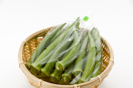 fresh okra in plastic bag on bamboo sieve