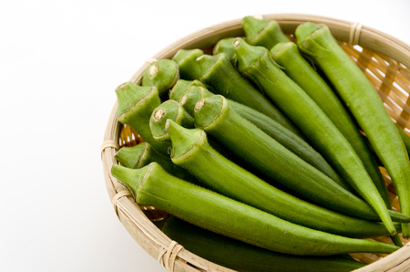 fresh okra in bamboo sieveの写真素材