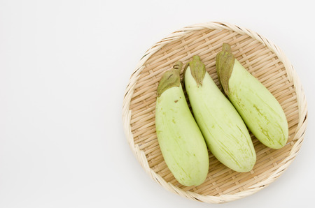 Green eggplant on bamboo sieve white backgroundの写真素材