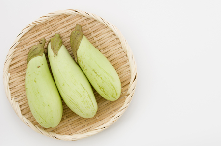 Green eggplant on bamboo sieve white backgroundの写真素材