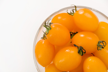 Fresh yellow cherry tomatoes in Glass bowlの写真素材