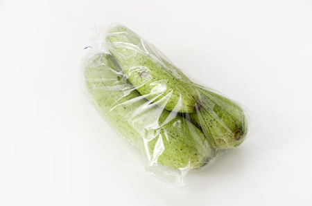 fresh green sponge gourd or luffa on black stone plate.の写真素材