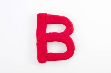 Red plasticine letter B uppercase of English alphabet isolated on white backgroundの写真素材