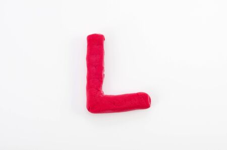 Red plasticine letter L uppercase of English alphabet isolated on white backgroundの写真素材