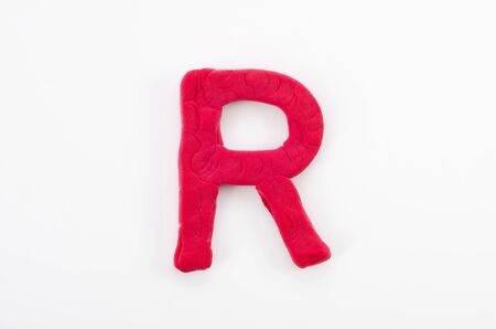 Red plasticine letter R uppercase of English alphabet isolated on white backgroundの写真素材