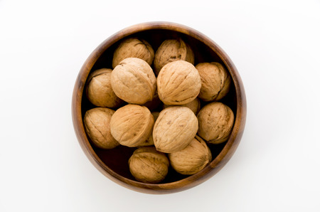 Walnut in a wooden bowl on a white backgroundの写真素材