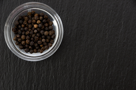 Black pepper in stacking bowl on black stone plateの写真素材