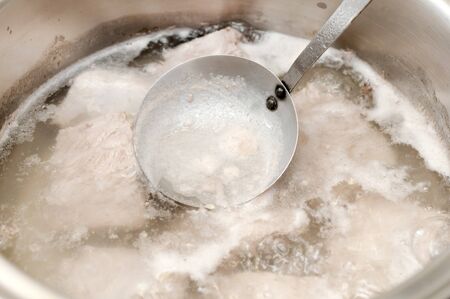 Boil pork in boiling water with Stainless steel pot on gas stove.
