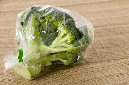 fresh broccoli in transparent plastic bag on  burlapの写真素材