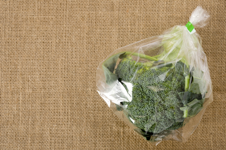fresh broccoli in transparent plastic bag on  burlapの写真素材
