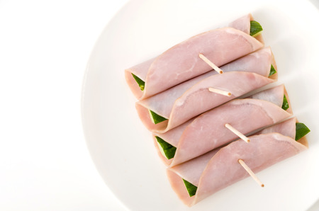 fresh Cucumber wrapped in loin ham on a dish on white backgroundの写真素材