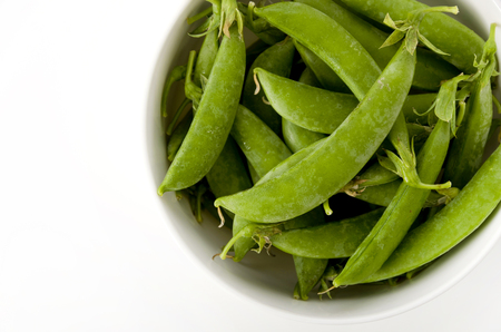 sugar snap pea in bowl on white backgroundの写真素材