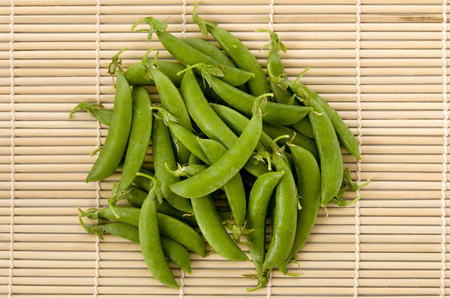 sugar snap pea on bamboo sushi matの写真素材