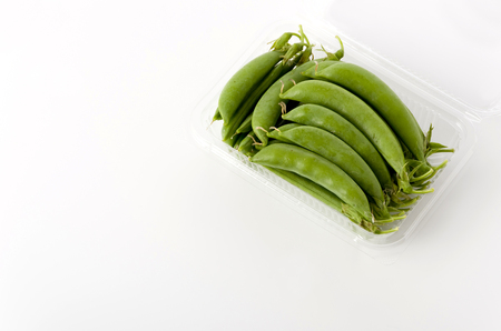 sugar snap pea  in plastic package on white backgroundの写真素材