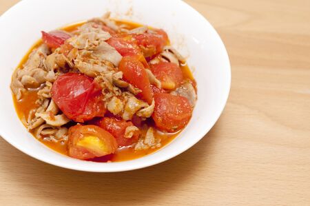 Chicken Tomato Stir Fry on wooden tableの写真素材