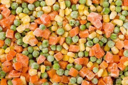 Frozen diced vegetables background with carrot, corn and peas.の写真素材