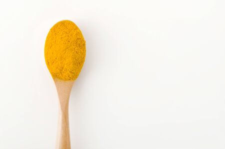 Turmeric (Curcuma) powder in wooden spoon on white background