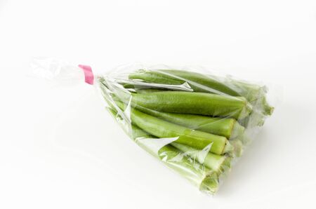 fresh Okra in plastic bag on white background