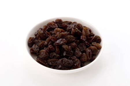 Raisins in small dish on white backgroundの写真素材