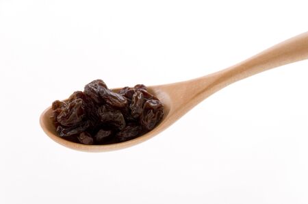 Raisins in a wooden spoon on whiteの写真素材