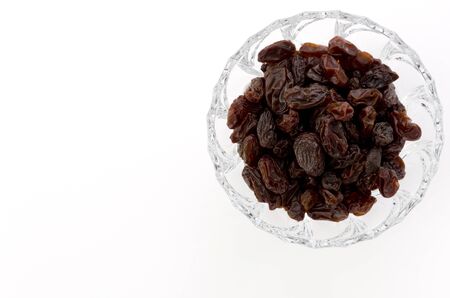 Raisins in Glass bowl on whiteの写真素材