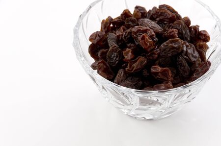 Raisins in Glass bowl on whiteの写真素材