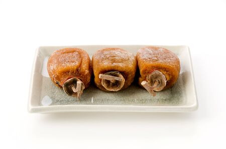 Dried persimmon on a plate on white backgroundの写真素材