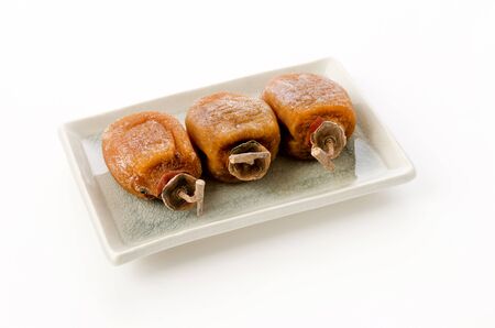 Dried persimmon on a plate on white backgroundの写真素材