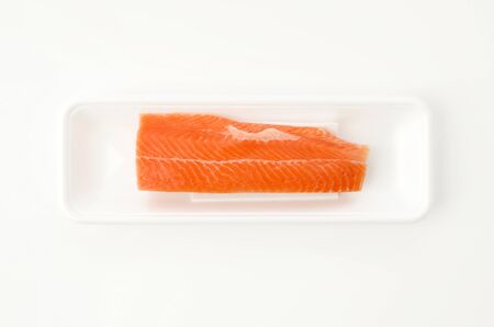 Rainbow trout fillet of on a white foam tray on white backgroundの写真素材