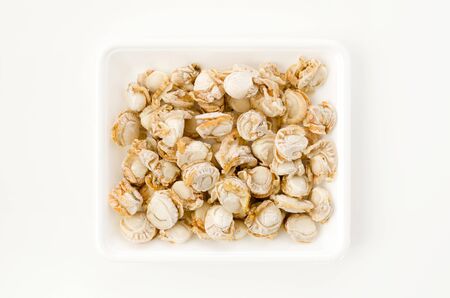 frozen seafood scallop meat on a white foam tray on white background