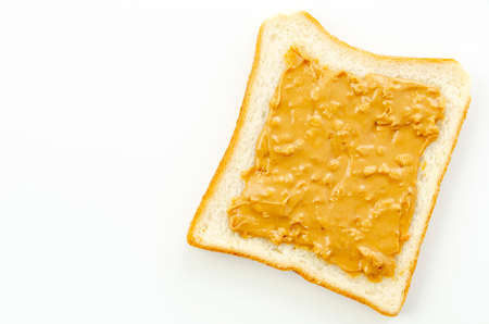 peanut butter on a slice of white bread.