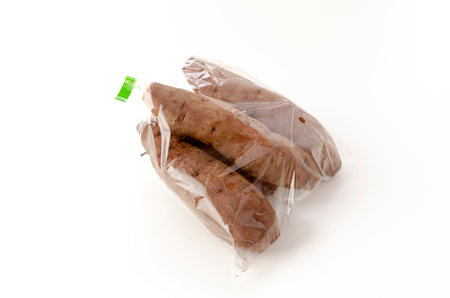 Purple sweet potatoes in Plastic bag on white backgroundの写真素材