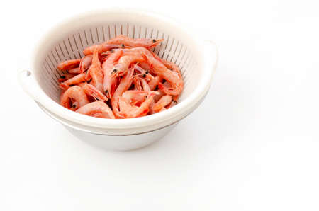 raw thawed small shrimps in a plastic colanderの写真素材
