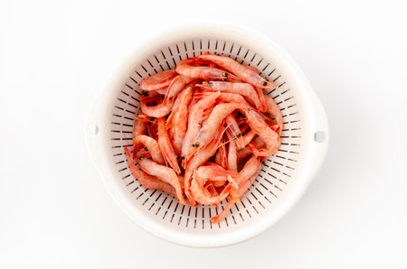 raw thawed small shrimps in a plastic colander