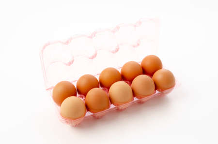 brown chicken eggs in plastic container on white backgroundの写真素材