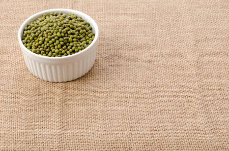 mung bean in ceramic cocotte on burlap background