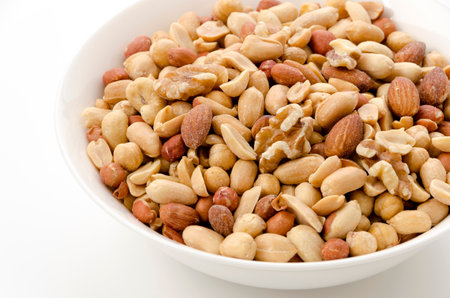 Mixed nuts in white bowl on white background