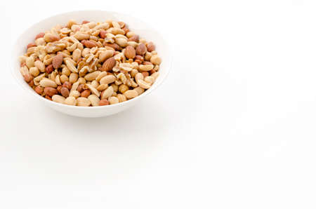 Mixed nuts in white bowl on white background