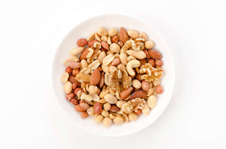 Mixed nuts in white bowl on white background
