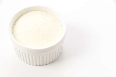 Skim milk powder in Cocotte on white backgroundの写真素材