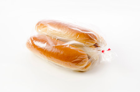 Hot dog bun in plastic bag on white background