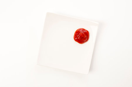 Tomato Ketchup on a white plate on white backgroundの写真素材