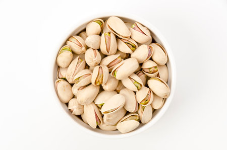 Pistachio nuts in cocotte on white background