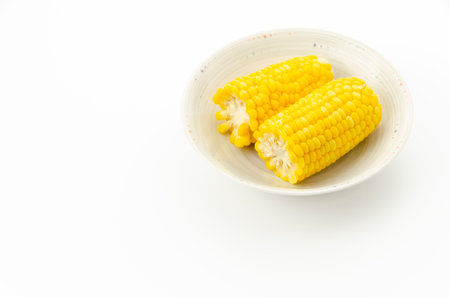 Boiled corn in a bowl on white backgroundの写真素材