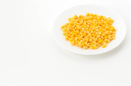 Canned sweet corn on a white plate on white backgroundの写真素材