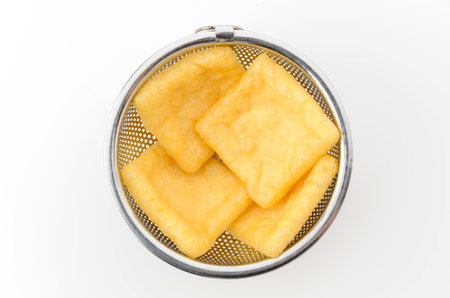 Abura-age, Fried tofu in a stanless steel colander on white background