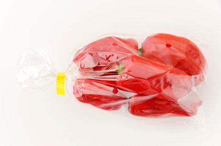 Fresh Red bell pepper in plastic bag on white backgroundの写真素材