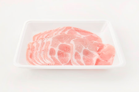 Thin Sliced pork shoulder loin on a foam food tray on white background