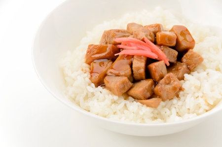 A bowl of white rice topped with braised tuna on isolated white backgroundの写真素材